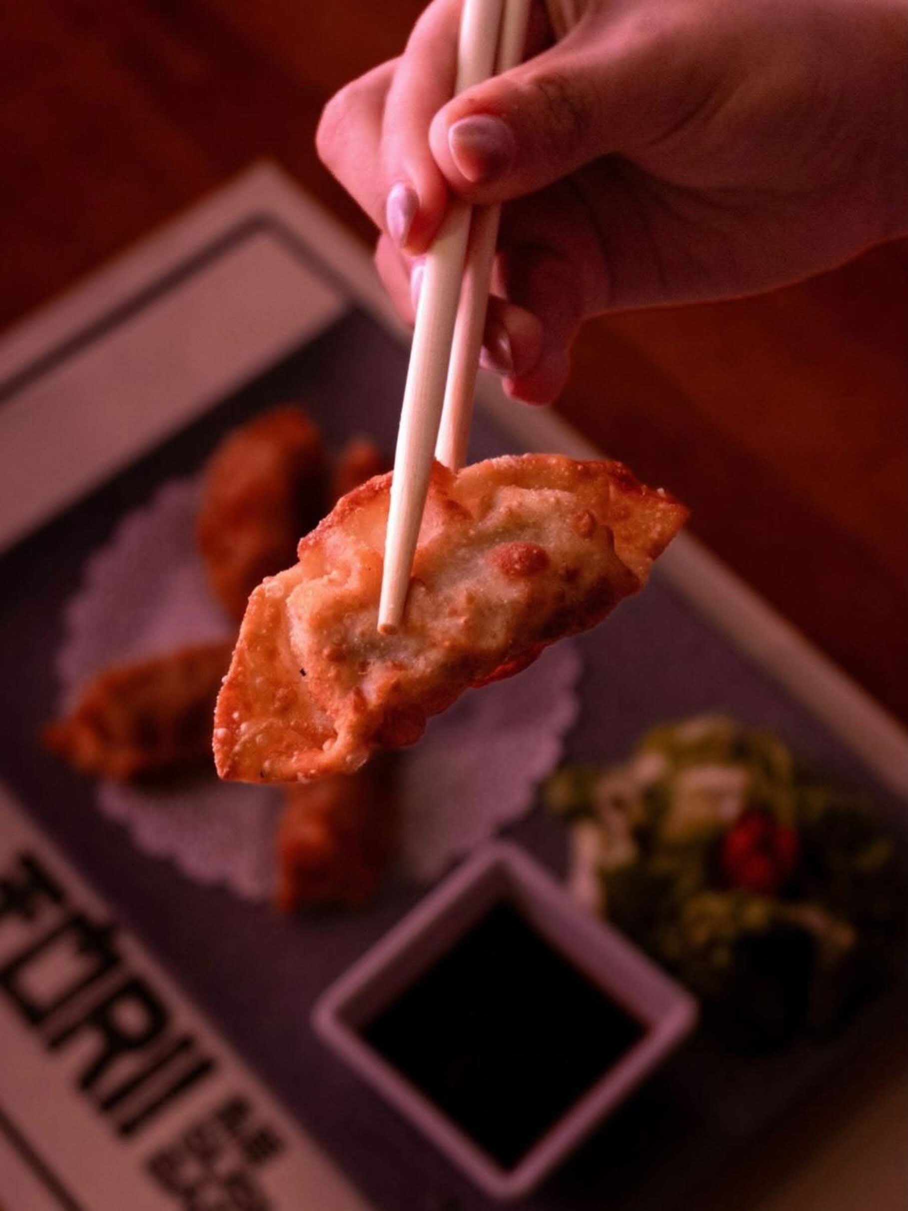 Gyoza sostenida con palillos